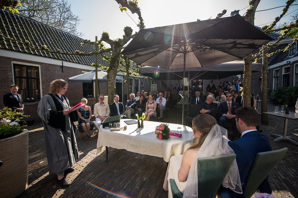 Trouwceremonie onder de bomen op de binnenplaats van Het Broeker Huis