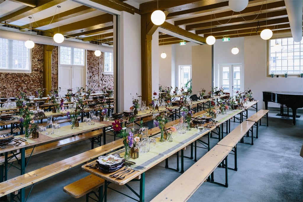 Grachtenzaal met lange tafels. 