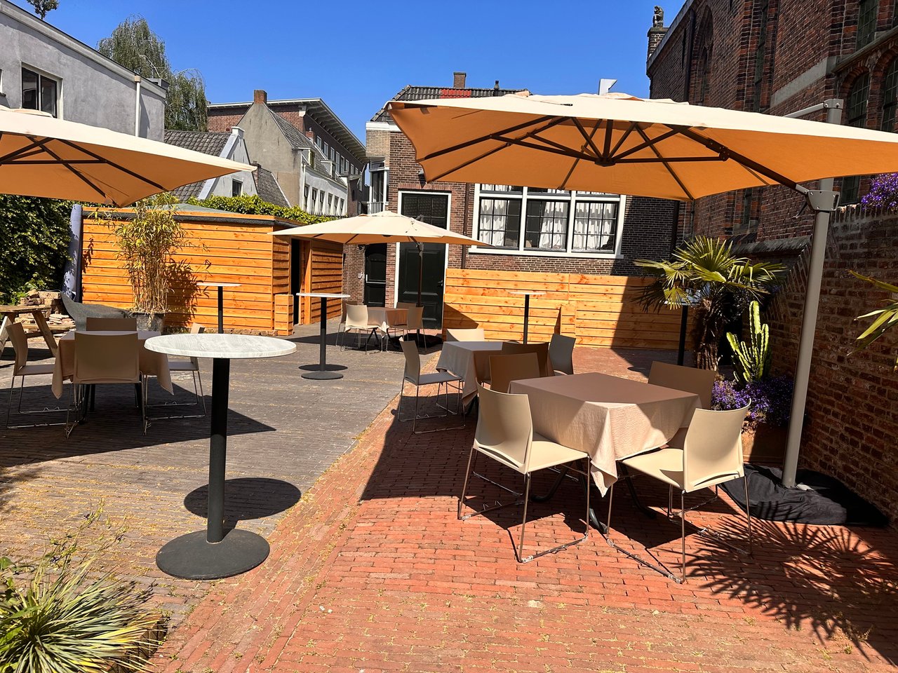 Besloten binnentuin met bartafels en parasols· Leeuwenbergh in centrum Utrecht 