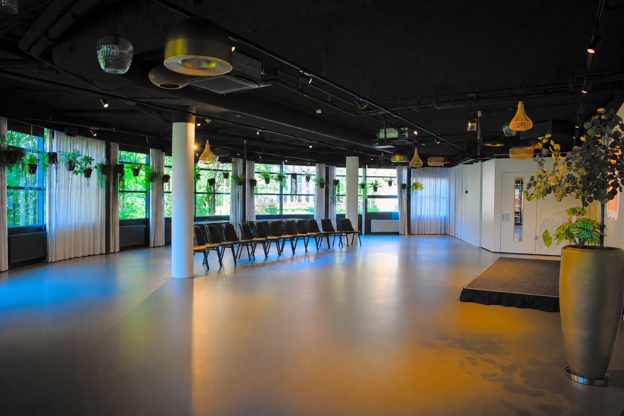 Ruime evenementenzaal met podium en daglicht