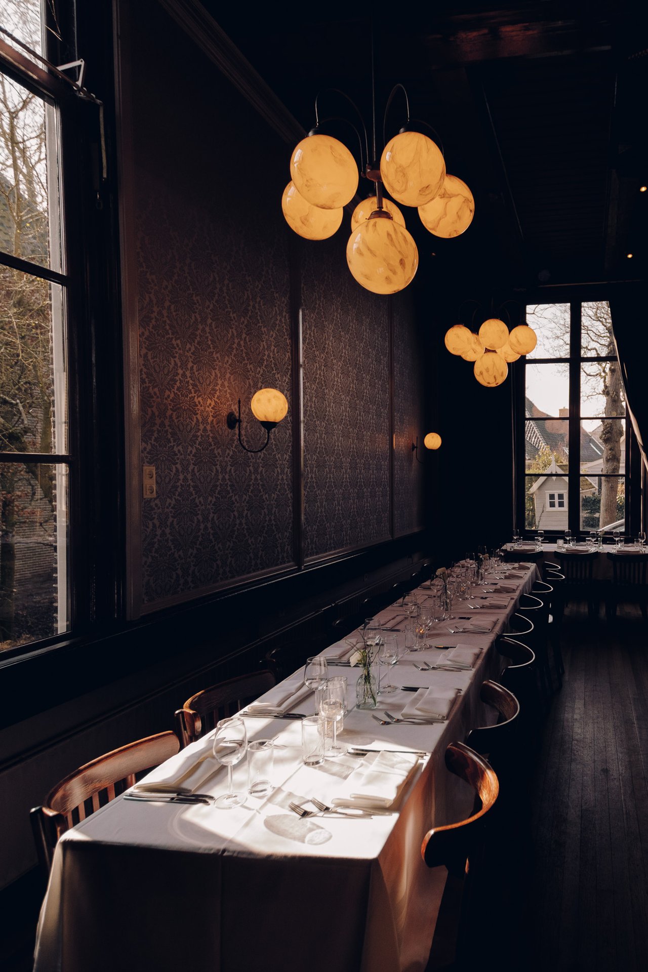 Lange, feestelijk gedekte tafel in de Grote Zaal van Het Broeker Huis