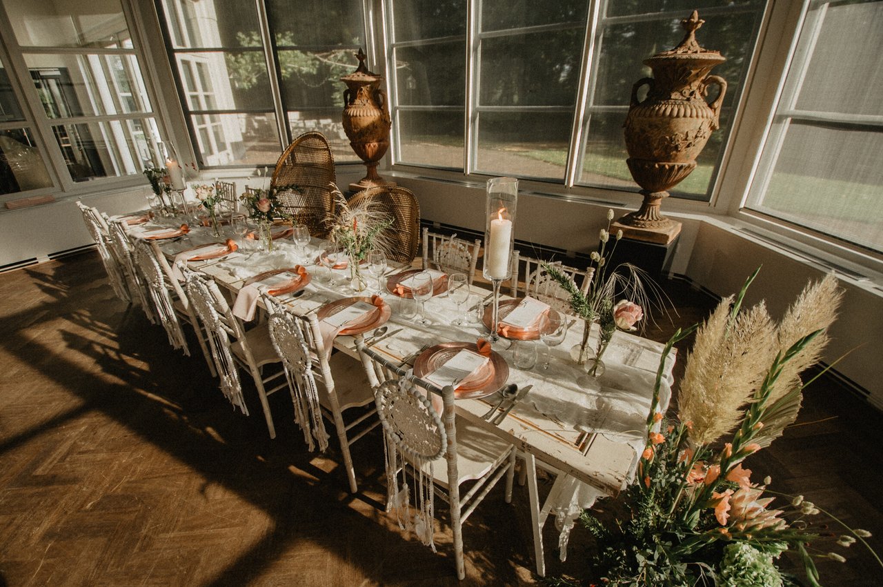 Gedekte dinertafel in de serre van het landhuis