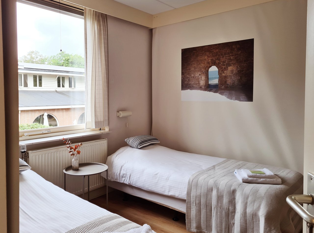 Tweepersoonskamer gedeelde douche en toilet hotelgebouw