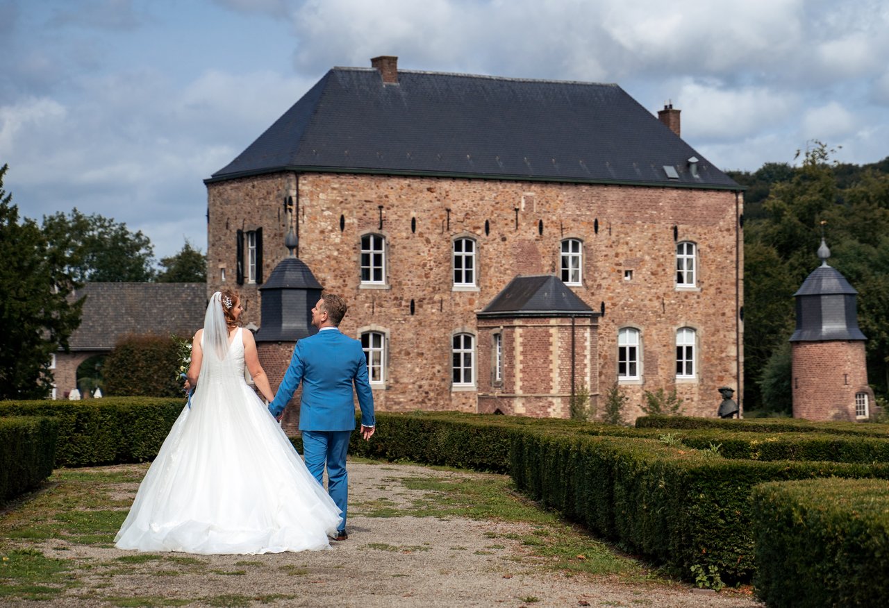 Bruidspaar wandelend door de kasteeltuin 