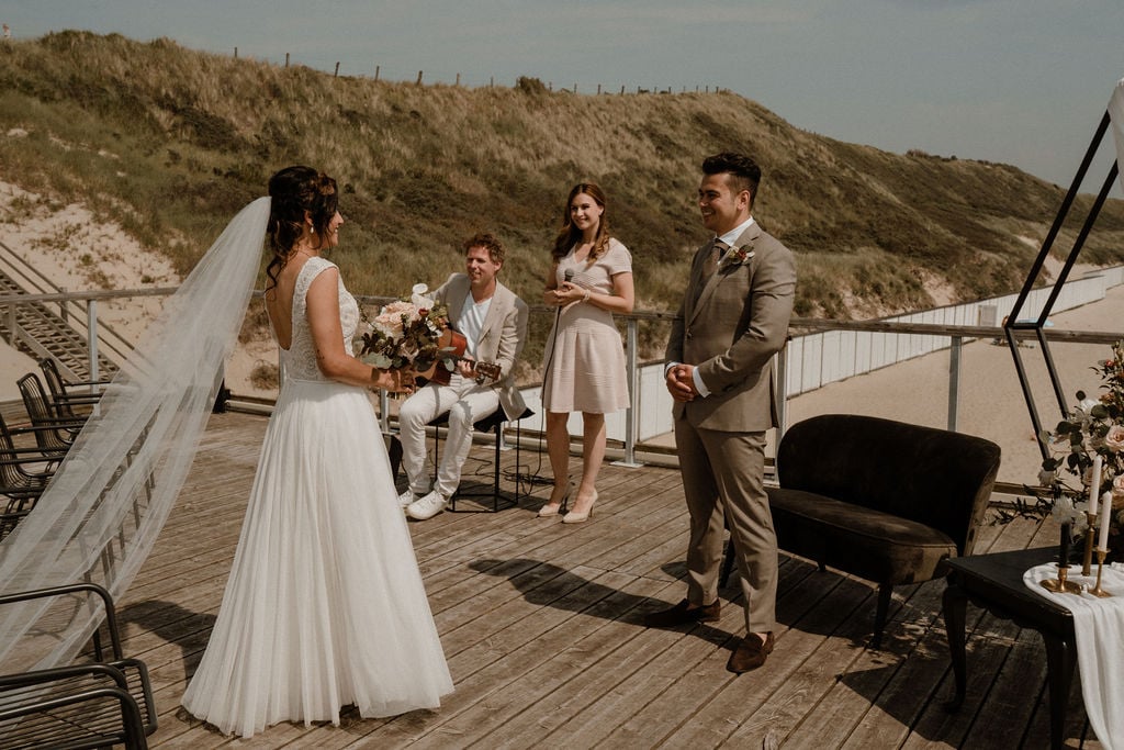 Bruidspaar ceremonie dakterras Beachclub Zuiderduin
