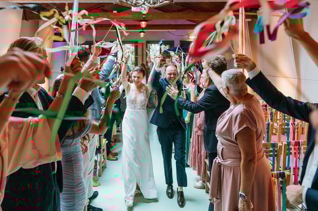 Bruidspaar loopt door kleurrijke erehaag