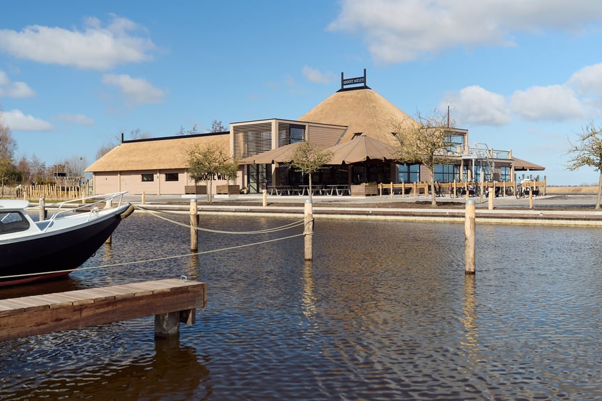 Foto van de voorkant van restaurant Groote Wielen in Leeuwarden, omringd door water, net buiten het centrum
